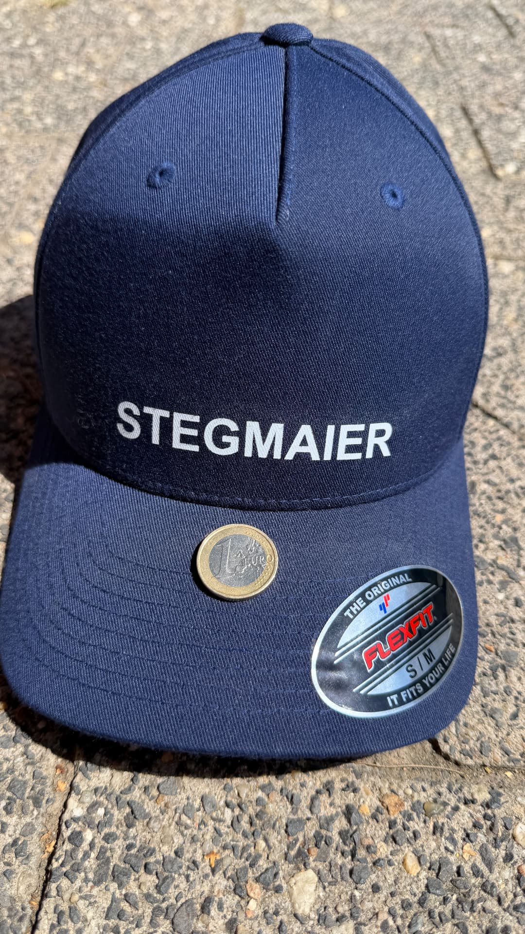 Dunkelblaue Cap mit Stegmaier-Schriftzug und einer 1-Euro-Münze